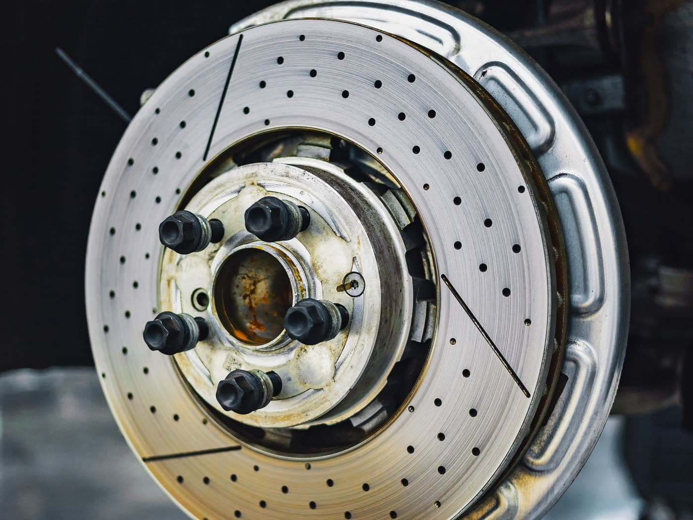 Close-up of a drilled brake rotor and wheel hub with the wheel removed